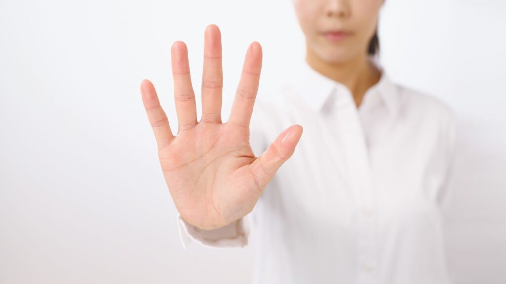 事業家集団環境で行っているメンバーの自己投資を止めている師匠の手のイメージ